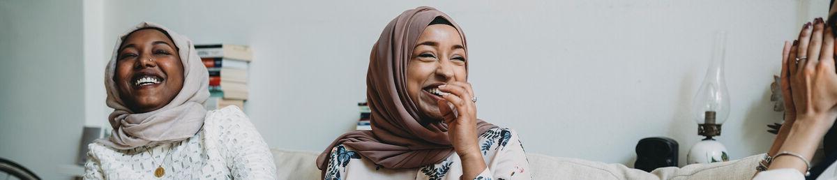 Close up of person in brown scarf, talking with a group of colleagues